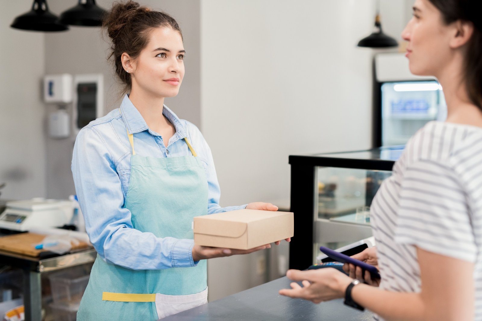 Shopkeeper Handing Box to Customer
